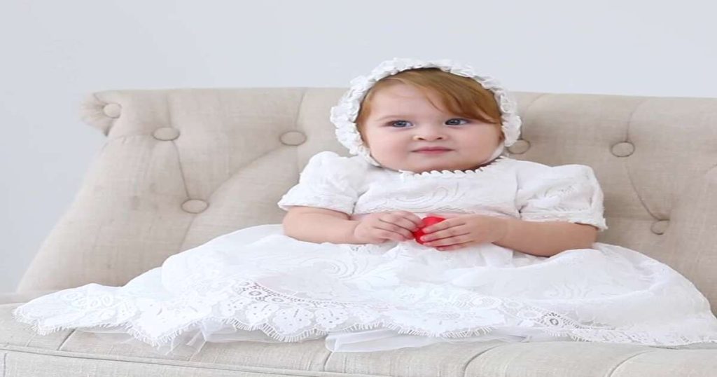 Baby girl in a white christening gown, one of many christening dresses for girls UK families choose