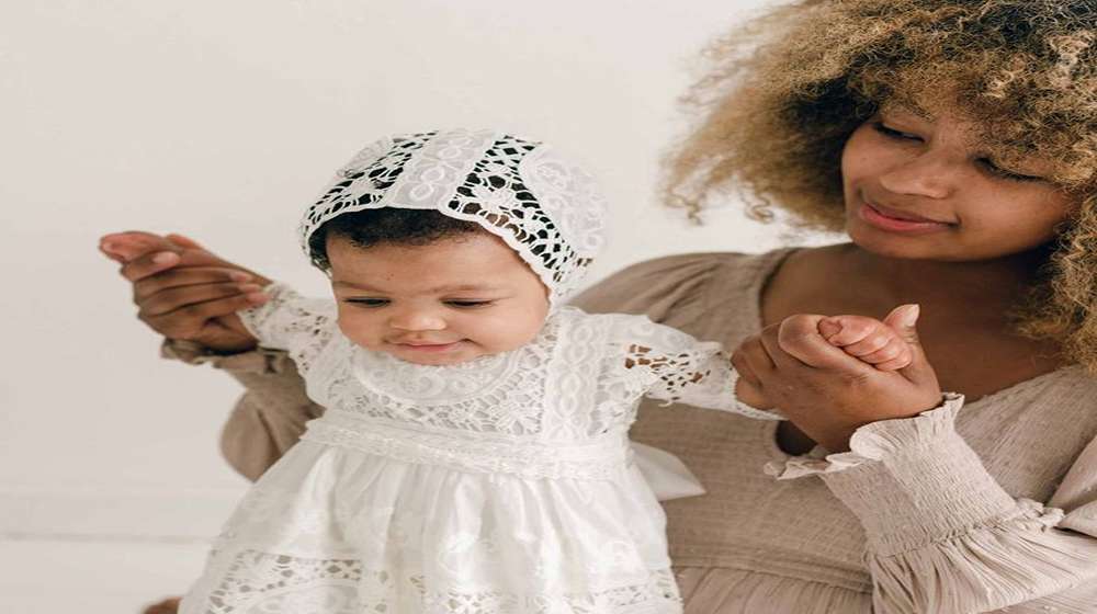 Girl in a soft cotton christening dress with lace detailing