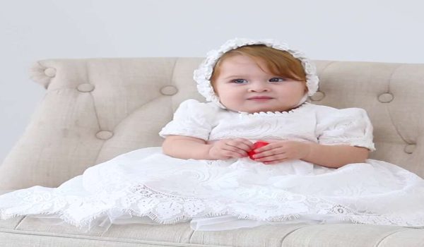 Baby girl in a white christening gown, one of many christening dresses for girls UK families choose